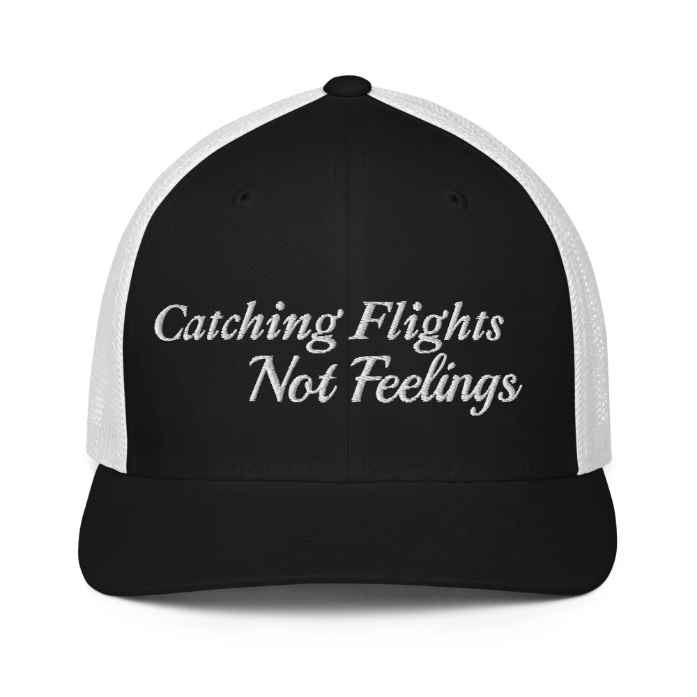 Black and white trucker hat with 'Catching Flights Not Feelings' text embroideredin white on a white background