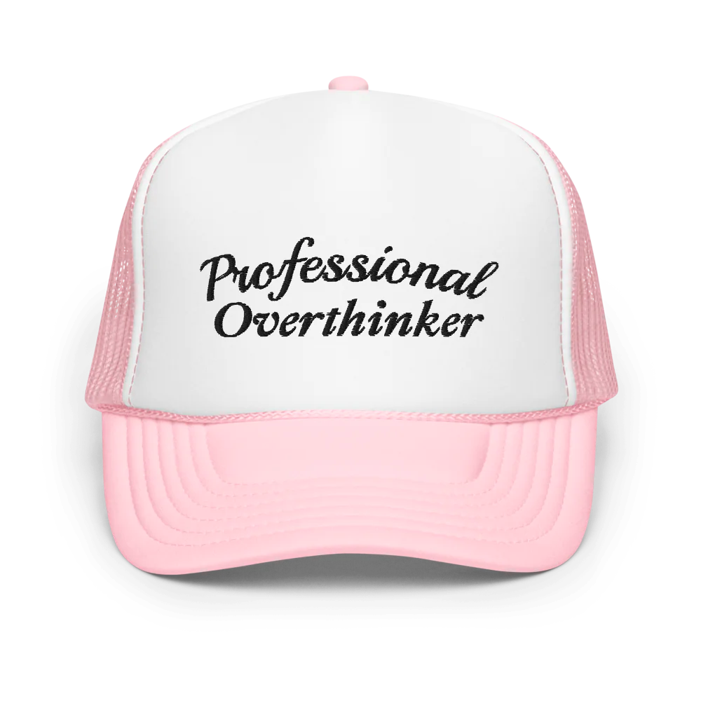 Pink and white trucker hat with 'Professional Overthinker' text on a white background