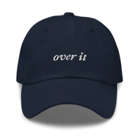 Navy blue baseball hat with 'over it' text embroidered in white on a white background