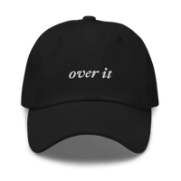 black baseball hat with 'over it' text embroidered in white on a white background
