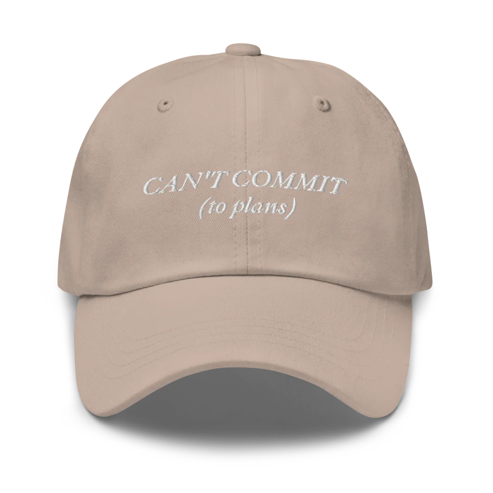 beige cap with text 'CAN'T COMMIT (to plans)' embroidered in white on a white background