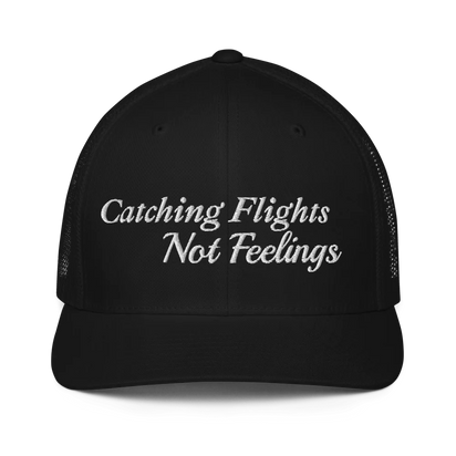 Black trucker hat with 'Catching Flights Not Feelings' text embroideredin white  on a white background