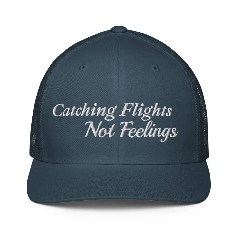 blue trucker hat with 'Catching Flights Not Feelings' text embroideredin white  on a white background