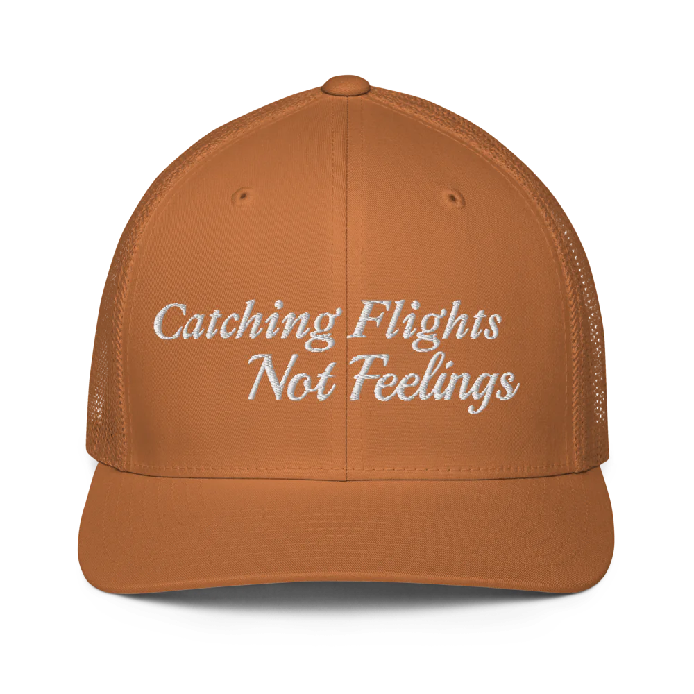 brown trucker hat with 'Catching Flights Not Feelings' text embroideredin white  on a white background
