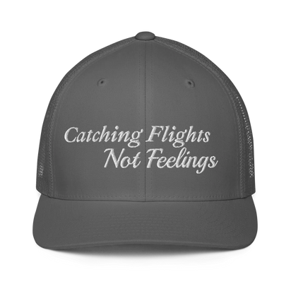gray trucker hat with 'Catching Flights Not Feelings' text embroideredin white  on a white background