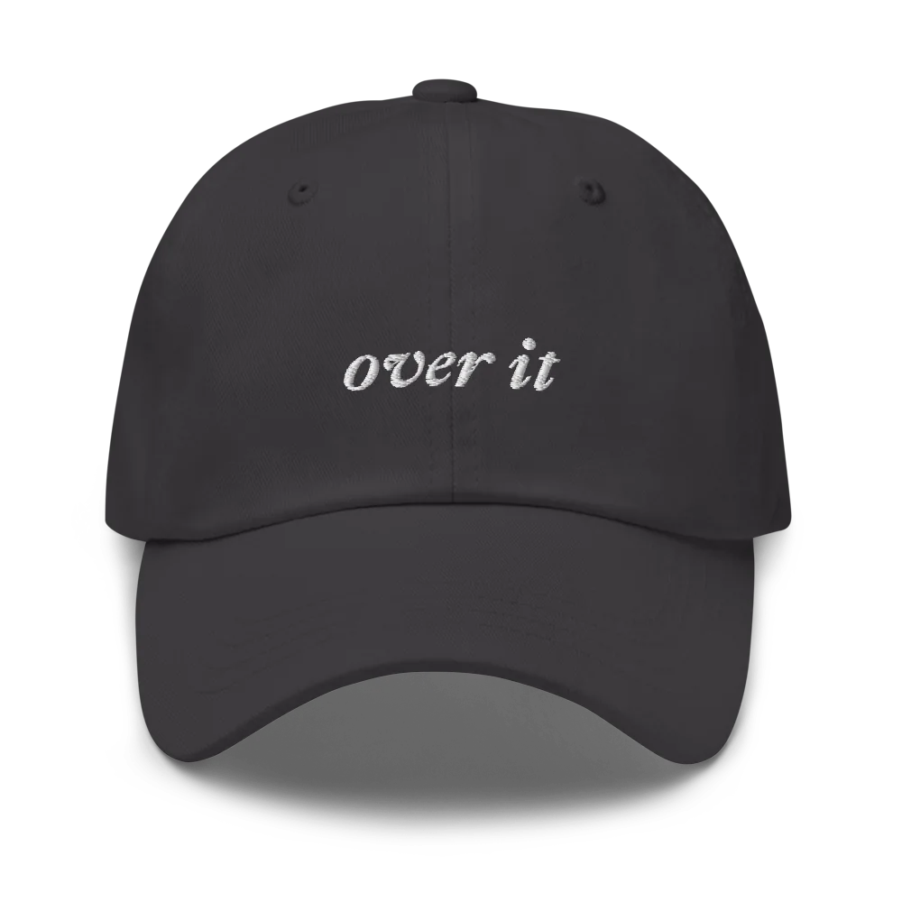Gray baseball hat with 'over it' text embroidered in white on a white background