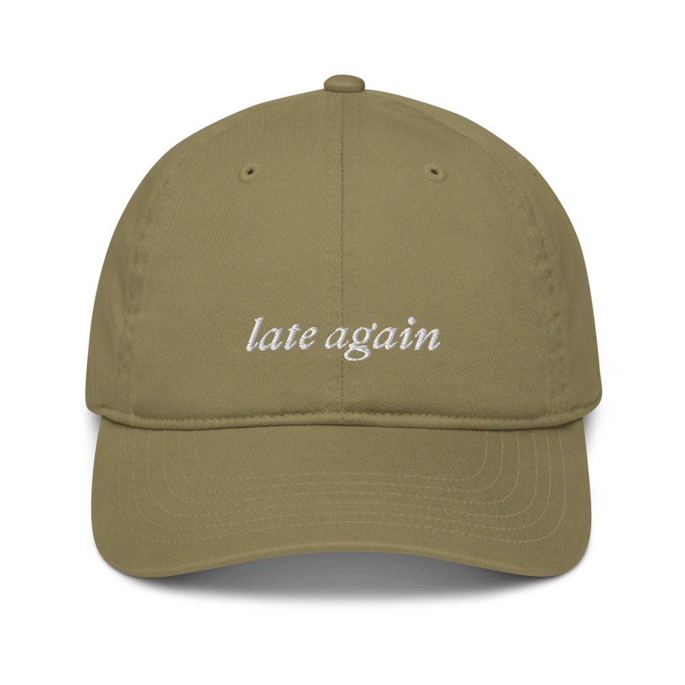 green baseball hat with 'late again' text embroidered in white on a white background