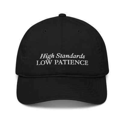 Black cap with 'High Standards Low Patience' text embroidered in white on a white background