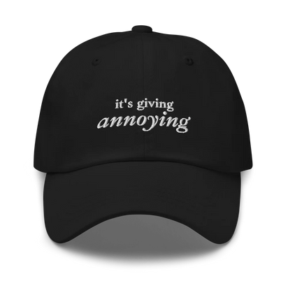 black baseball hat with white text 'it's giving annoying' embroidered on front