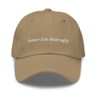 khaki baseball hat with 'better late than ugly' text embroidered in white on a white background