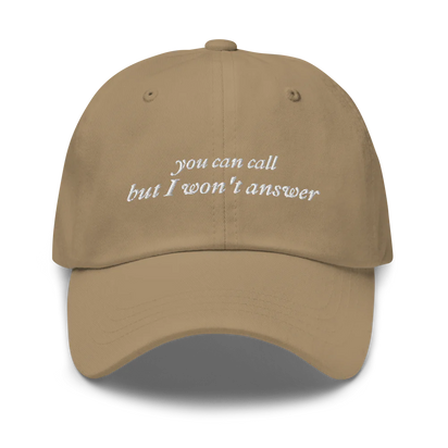 Khaki baseball hat with white embroidered text 'you can call but I won't answer' on a white background