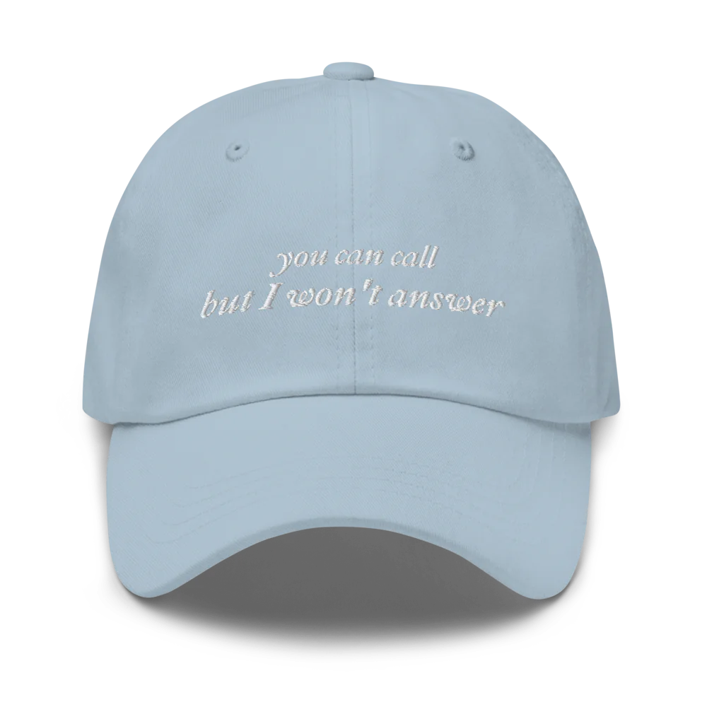 Light Blue baseball hat with white embroidered text 'you can call but I won't answer' on a white background
