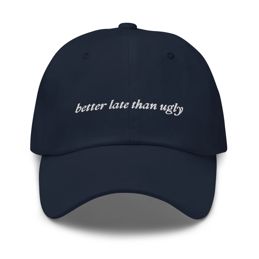 navy baseball hat with 'better late than ugly' text embroidered in white on a white background