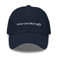 navy baseball hat with 'better late than ugly' text embroidered in white on a white background