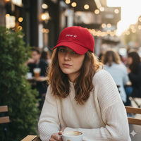 Red baseball hat with 'over it' text embroidered in white on a white background