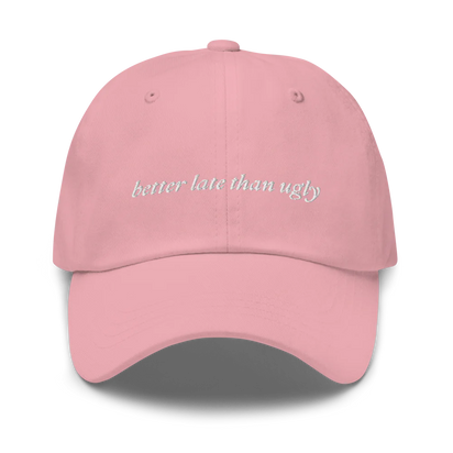 pink baseball hat with 'better late than ugly' text embroidered in white on a white background