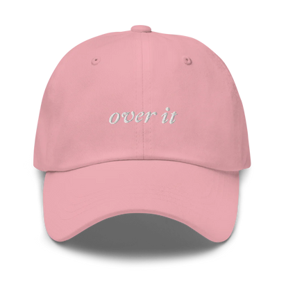 pink baseball hat with 'over it' text embroidered in white on a white background
