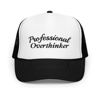 Black and white trucker hat with 'Professional Overthinker' text on a white background