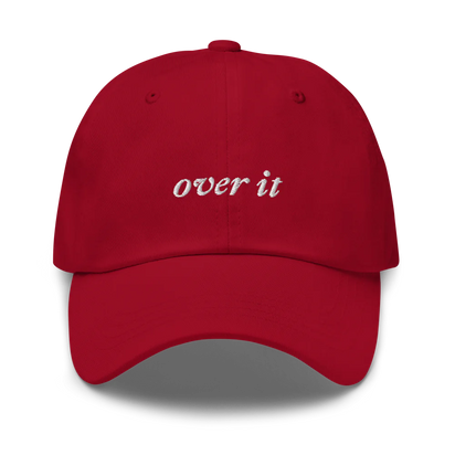 red baseball hat with 'over it' text embroidered in white on a white background
