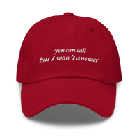 Red baseball hat with white embroidered text 'you can call but I won't answer' on a white background