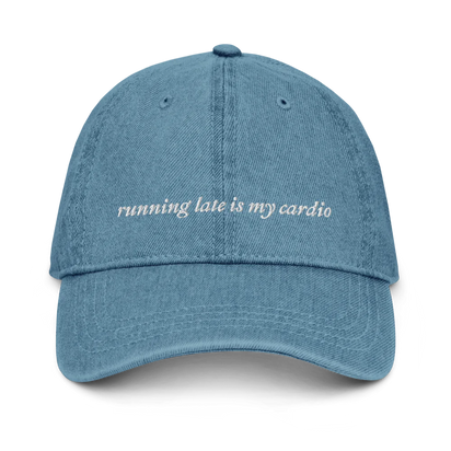 denim baseball hat with white embroidered text 'running late is my cardio' on a white background